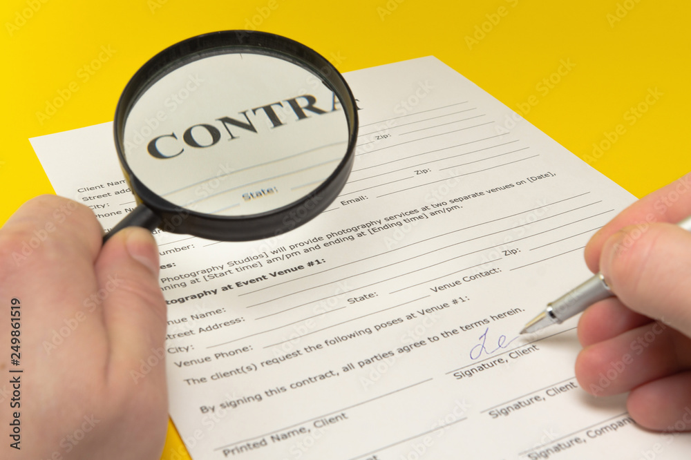 The contract on the yellow table, magnifier and pen. The contract on the yellow table, magnifier and pen.