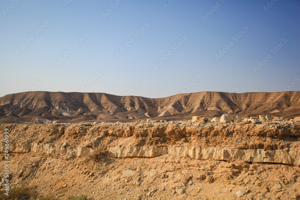View of the hill in the desert. Blue sky. The ashy desert landscape.
