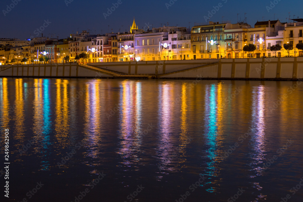 Sevilla, Andalusia, Spain - 04/01/2019 the vibrant calle Betis (english translation: Betis Street) in Sevilla during blue hour. The street is located in Triana and on the bank of Guadalquivir river