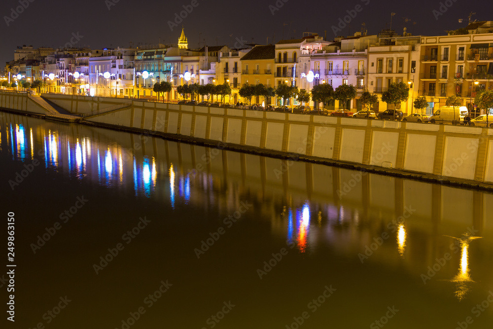 Sevilla, Andalusia, Spain - 04/01/2019 the vibrant calle Betis (English translation: Betis Street) in Seville during blue hour. The street is located in Triana and on the bank of Guadalquivir river