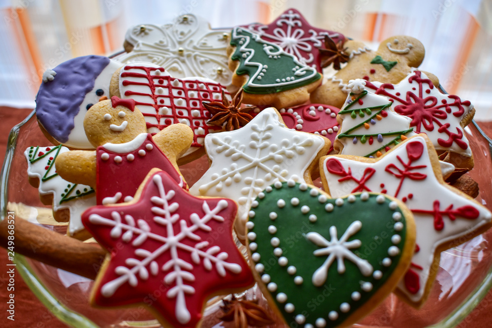 Traditionally decorated Christmas gingerbread cookies on a blass bowl