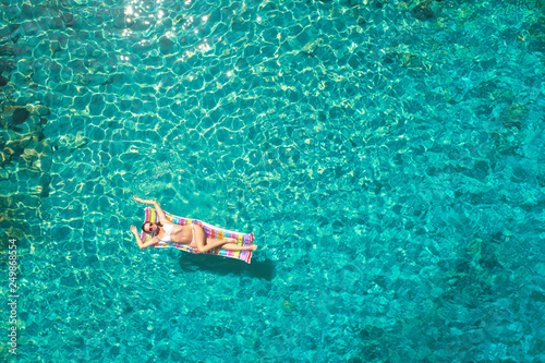 aerial view of a beautiful young woman in bikini on a matress in the sea © ZoomTeam