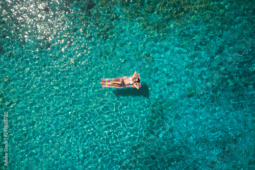 aerial view of a beautiful young woman in bikini on a matress in the sea © ZoomTeam