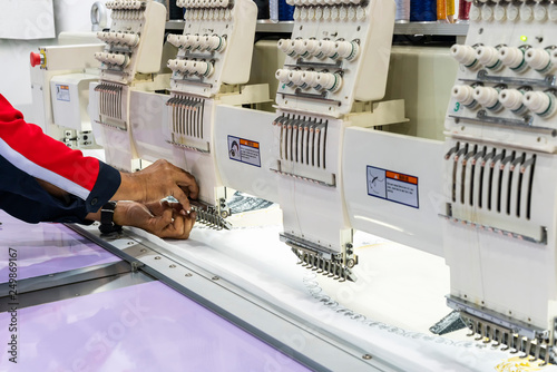 Obraz na plátně Operator or tailor working on modern and automatic high technology sewing machin