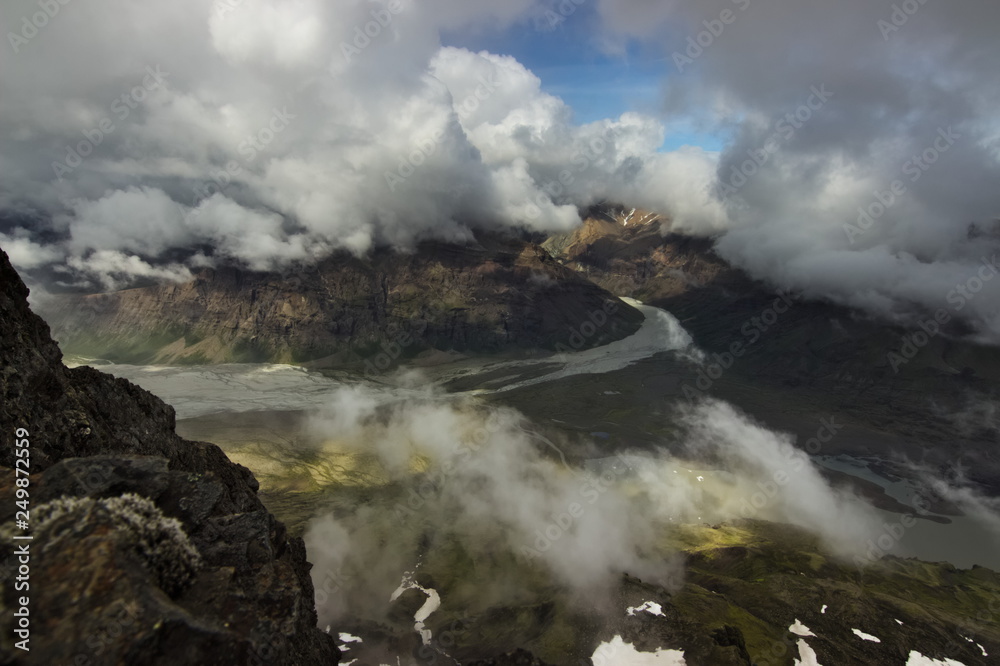 View from the top of the mountain over the valley with clouds above it in Skaftafell national park in Southern Iceland.