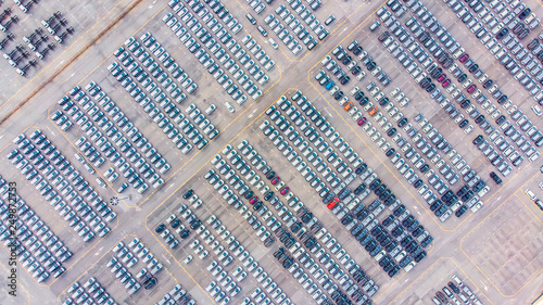 Fototapeta Naklejka Na Ścianę i Meble -  Transportation aerial view from drone top view new cars lined up in the port for import and export.Stock waiting for export
