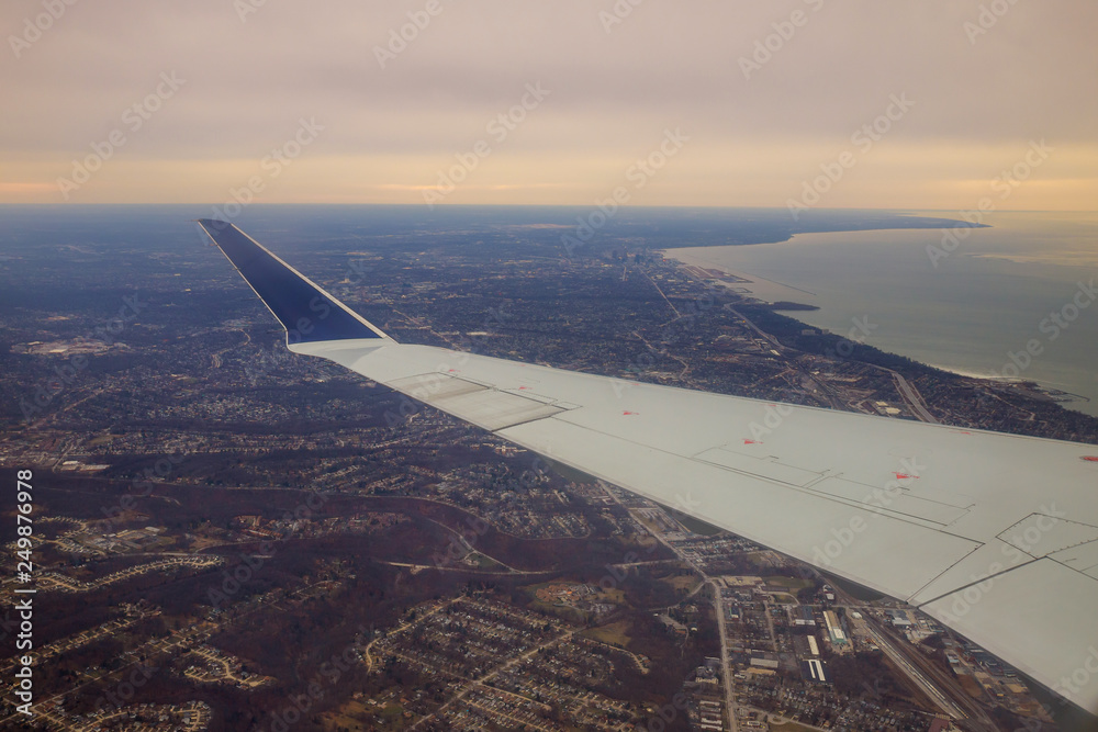 Winglet in graduated dark blue sky with a view of big city below in Cleveland Ohio.