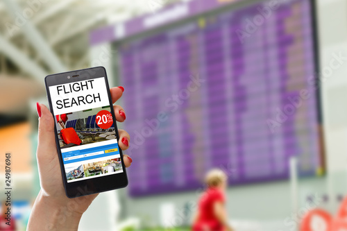 E-ticket on smartphone screen with timetable in the blurred background. Buying online ticket from internet. Universal public transportation terminal. Bus, train, metro, subway or underground station