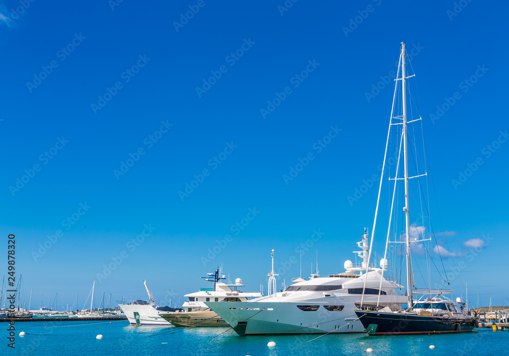 Sailboats and Yachts on blue water and sky in marina