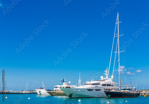 Sailboats and Yachts on blue water and sky in marina
