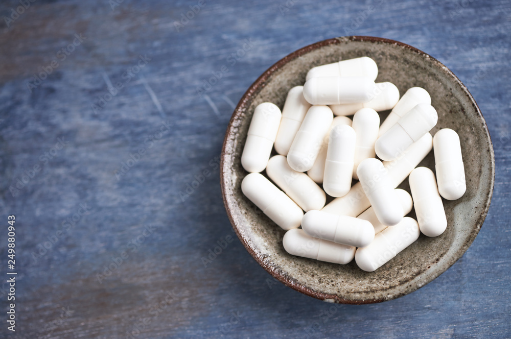 Beta-alanine capsules. Bodybuilding food supplements on rustic wooden background. Top view. Close up. Copy space. Beta-alanine capsules. Bodybuilding food supplements on rustic wooden background. Top view. Close up. Copy space.