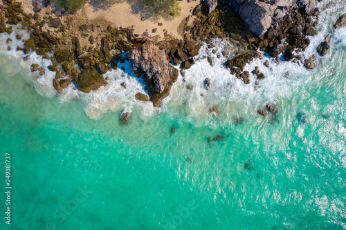 Aerial top view of ocean waves, beach and rocky coastline and beautiful forest. Beautiful nature background. © Sunday Stock