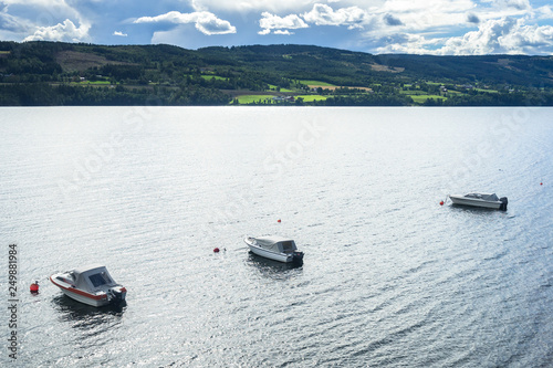 Three boats surrounded by the beautiful landscape of Mjosa lake during summer, Hedmark, Norway photo