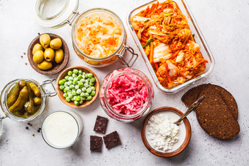 Probiotics food concept. Kimchi, beet sauerkraut, sauerkraut, cottage cheese, peas, olives, bread, chocolate, kefir and pickled cucumbers.