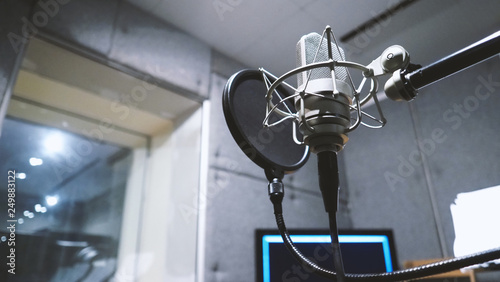 Studio microphone or mic for recording for vocal singer or commercial announcer with shock mount and pop filter on professional tripod in acoustic foam room for best sound and mix process photo