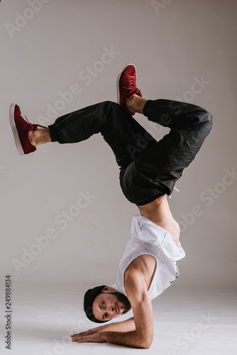 Canvas Print A man hip hop dancer or bboy freezes in one pose on the hand
