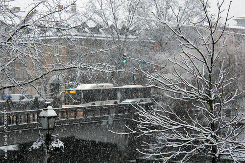 Tormenta di neve in città con traffico e semaforo photo