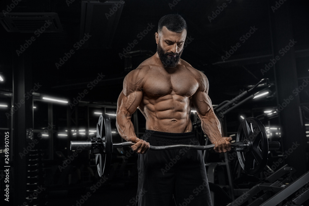 Muscular man working out in gym doing exercises, strong male naked torso abs - Изображение