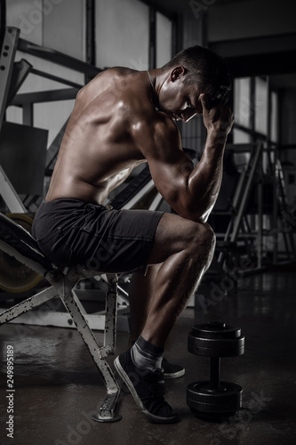 Fitness guy in pose of thinker