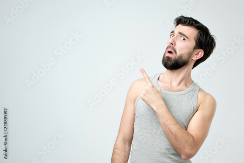 Attractive young spanish man pointing up with his finger