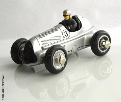 vintage racing car toy silver color over white background © FERNANDO