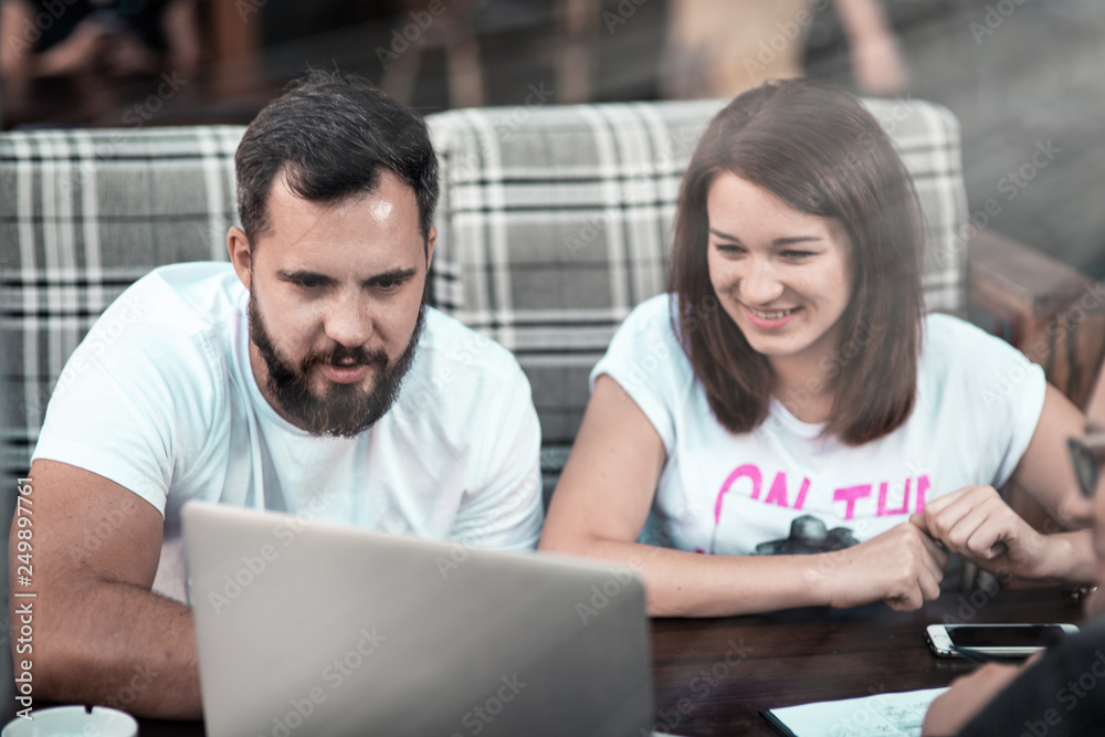 Businessmen discuss the deal and control it online, in a cafe on the street. A girl and two guys. Businessmen discuss the deal and control it online, in a cafe on the street. A girl and two guys.