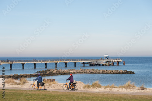 Fototapeta Naklejka Na Ścianę i Meble -  Der Ostküsten-Radweg an der Ostseeküste entlang hier Radwanderer vor der Seebrücke in Schönberger Strand