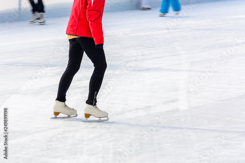 A young slender girl skates and helps beginners