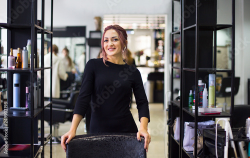 Beautiful young hairdresser in beauty salon