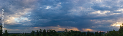 Landscape with dramatic light - beautiful golden sunset with saturated sky and clouds.