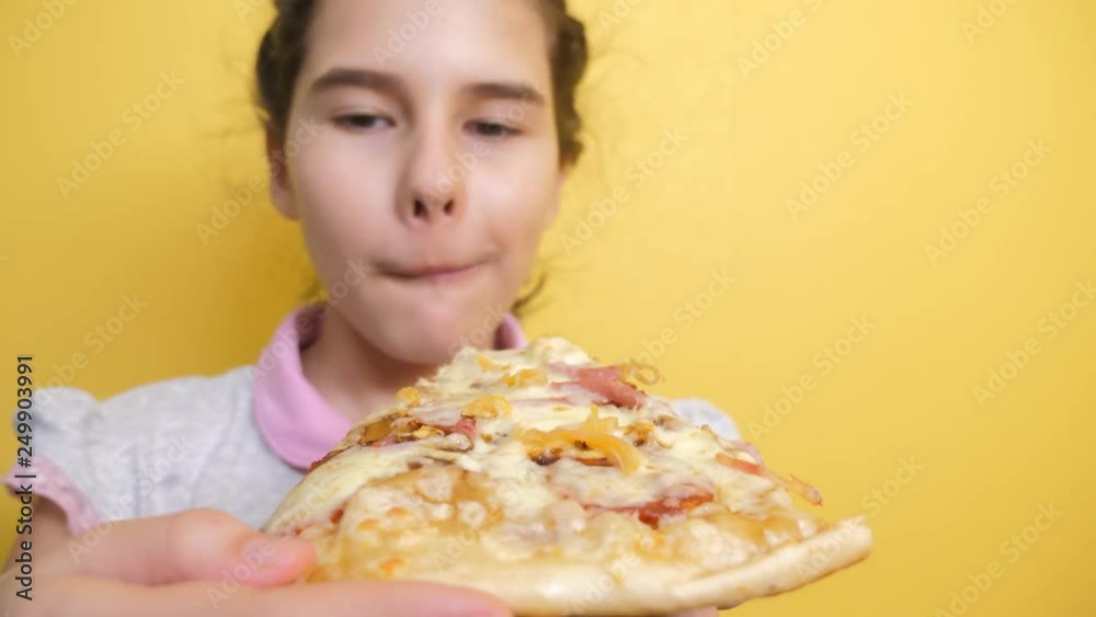 happy little girl eating a slice of pizza concept. teenager child hungry eats a slice of pizza. slow motion video. pizza fast food concept lifestyle happy little girl eating a slice of pizza concept. teenager child hungry eats a slice of pizza. slow motion video. pizza fast food concept lifestyle
