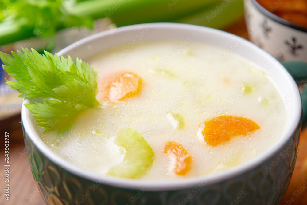A bowl of cheese soup with celery and poultry meat A bowl of cheese soup with celery and poultry meat