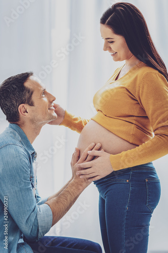 Young pregnancy standing in front of her husband