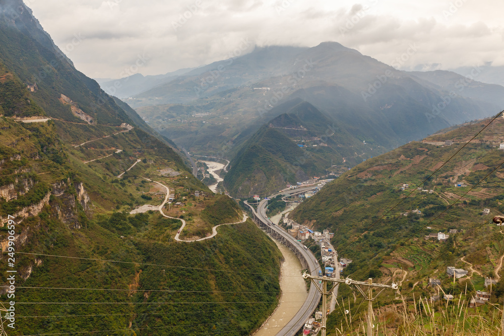 highway passes in a gorge in the mountains along the river, Heng River, Yunnan Province, China