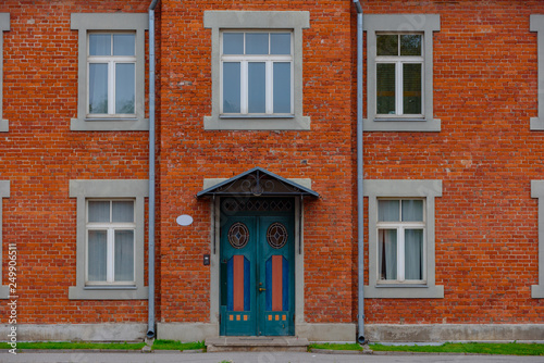 Red brick building facade with wooden door and windows