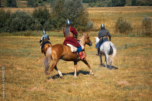 Three medieval armored knights on horses
