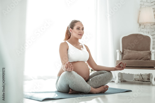 Precious woman with long ponytail sitting with crossed legs