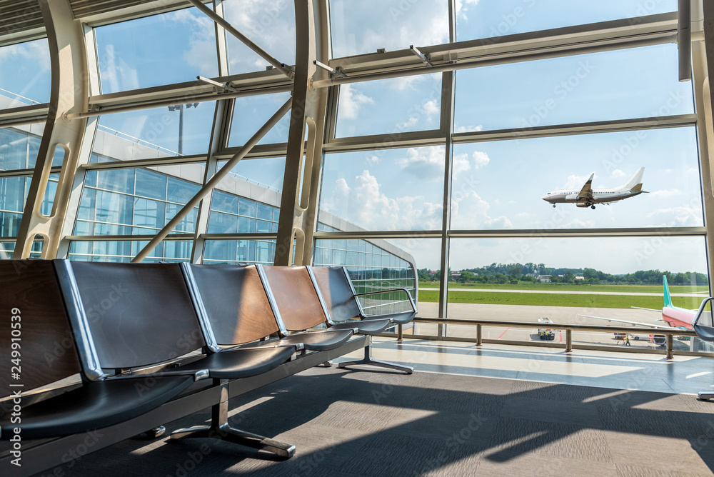 Passenger seat in Departure lounge and landing plane, view from airport  terminal. Vacation, transport and travel concept foto de Stock | Adobe Stock