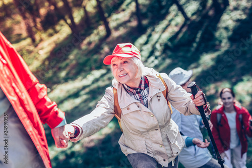 Slika na platnu Beaming elderly lady wearing comfortable clothing hiking