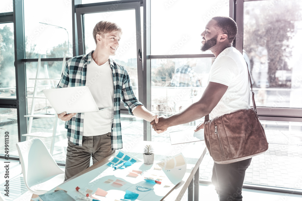 Obraz premium Handsome blonde man shaking hands with his visitor