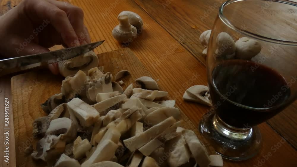 Preparando hongos mientras se toma vino
