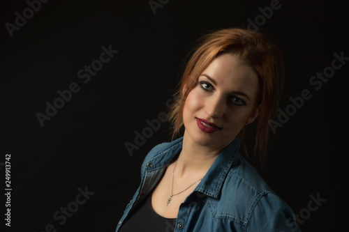 Low key portrait of posing young attractive woman on the black background. Horizontally. 