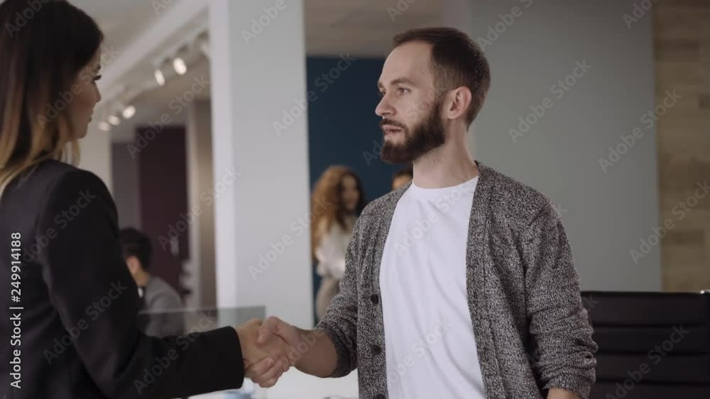 Candid creative busines man and woman in office habdshaking hands and discussing succesefull project Candid creative busines man and woman in office habdshaking hands and discussing succesefull project
