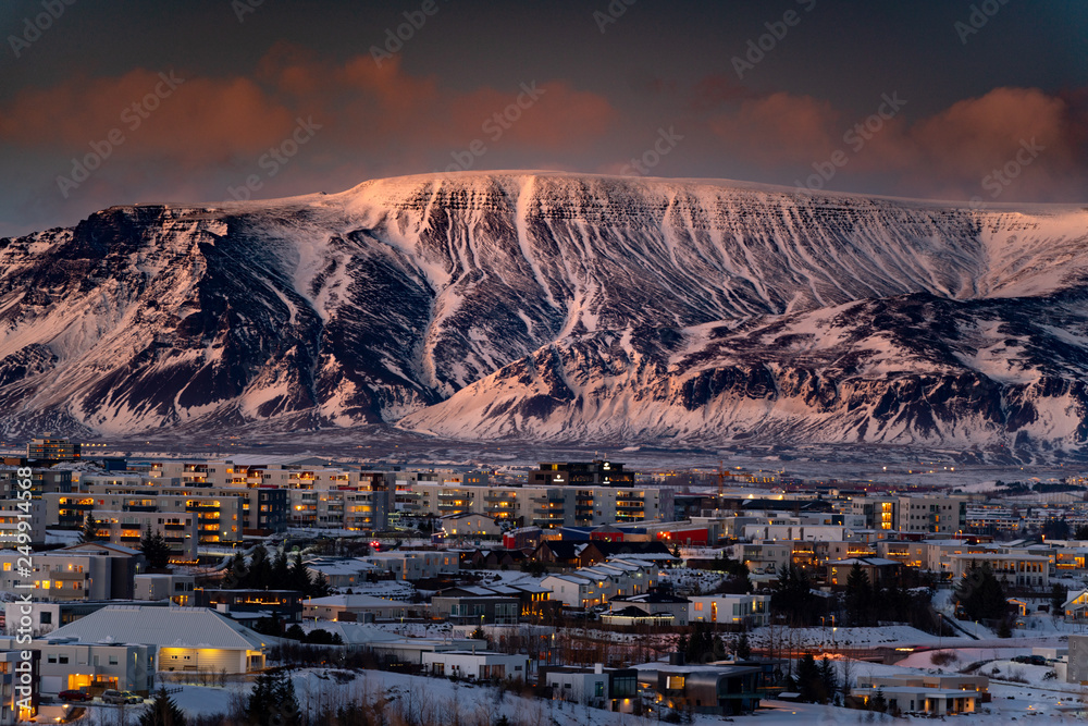 Large mountains rising over Reykjavik City during sunset - obrazy, fototapety, plakaty 