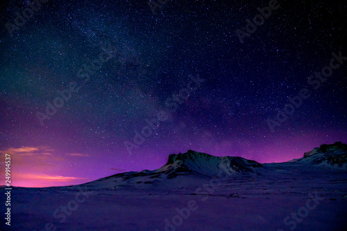 Starry sky behind mountains just before sunrise