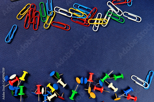 colored paper clips, button  on a dark blue background. 