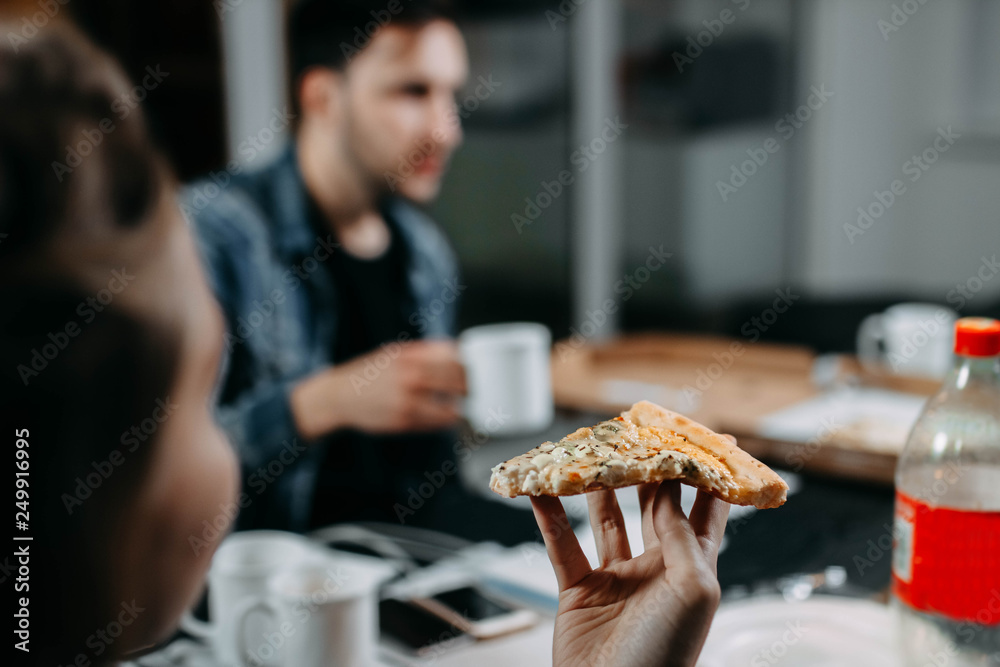 eating an appetizing pizza in the office. fast food delivery concept eating an appetizing pizza in the office. fast food delivery concept