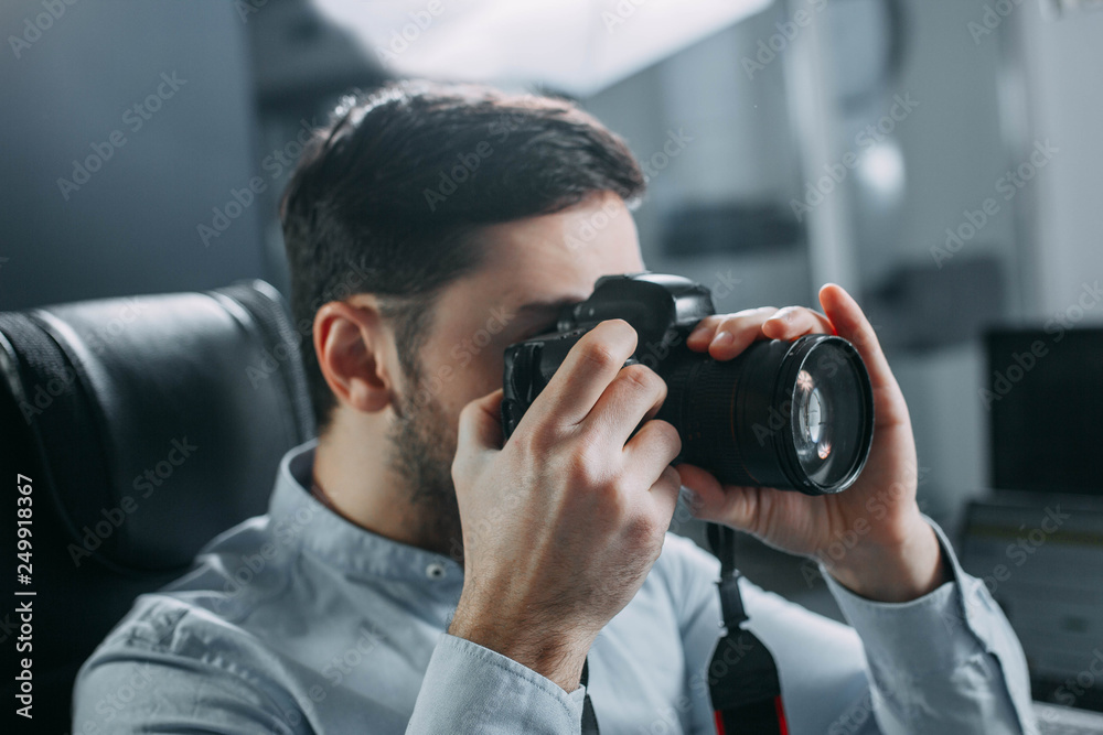 male photographer with a camera workplace in the office. male photographer with a camera workplace in the office.