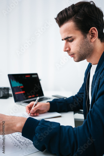 Fototapeta Naklejka Na Ścianę i Meble -  Architect design concept blueprint. Young man designer sketching a construction project at notebook and drawing plan while working at office. Vertical