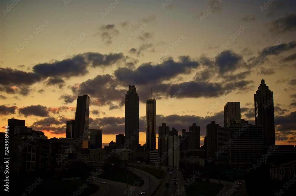Fototapeta premium A dramatic silhouette of a cluster of buildings set against a golden sunset.